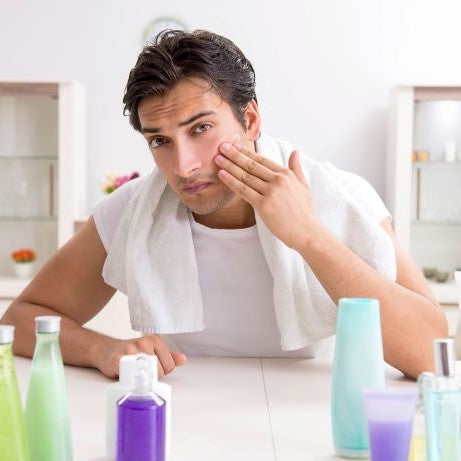 Man applying moisturizer to his face as part of his self-care routine