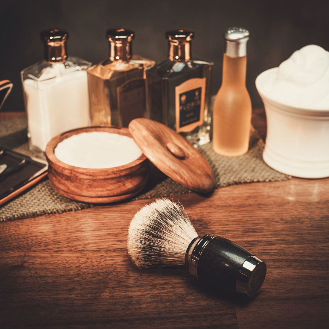 Assortment of beard maintenance items including a badger hairbrush, shaving soap, and beard oil